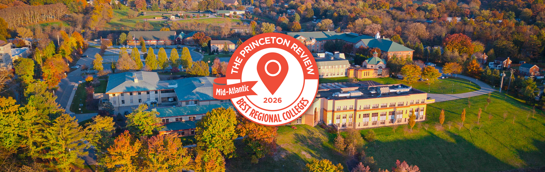 Aerial view of the La Roche University campus with buildings surrounded by trees during autumn. The image includes a logo of The Princeton Review Mid-Atlantic Best Regional Colleges 2025.