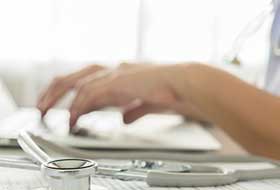 Hands typing on laptop keyboard