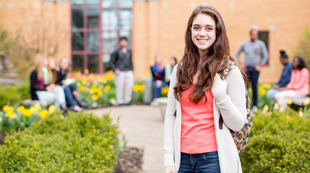 Female student standing outside in front of Magdalen Chapel at La Roche University.