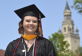 Alumnus on campus with Providence Heights in the background.