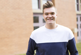 Male student in front of the Zappala Campus Center.