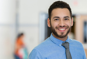 A man in professional clothing smiles.