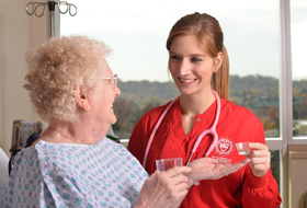 Nursing student giving medication to patient in hospital