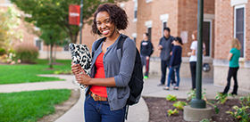 Students holding books outside in front of Bold Hall