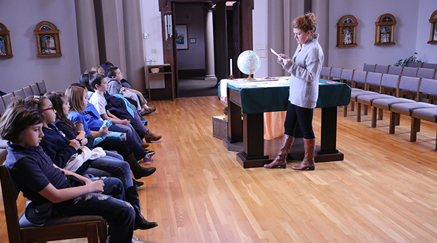 La Roche instructor reading to Alpha School students in Magdalen Chapel