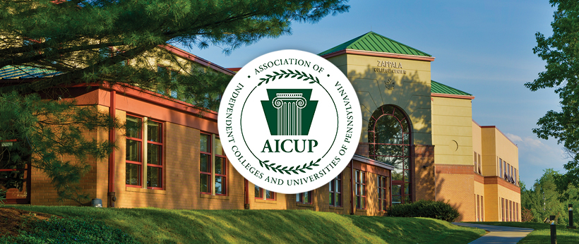 Economic Impact Exterior view of La Roche University's Zappala Campus Center Square building under a clear sky, featuring lush greenery and the logo of the Association of Independent Colleges and Universities of Pennsylvania (AICUP).