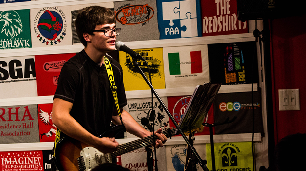 Male student playing guitar and singing